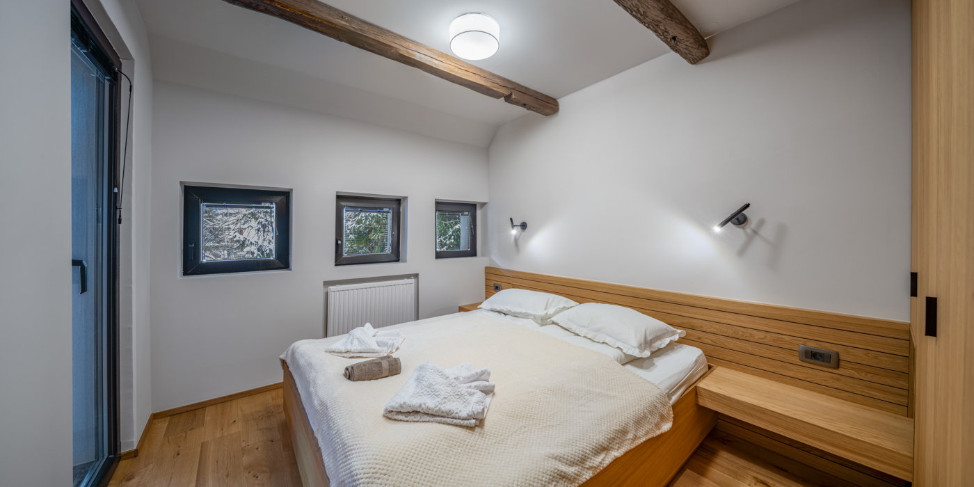 Zakonska spalnica apartmaja Jakob z lesenimi detajli